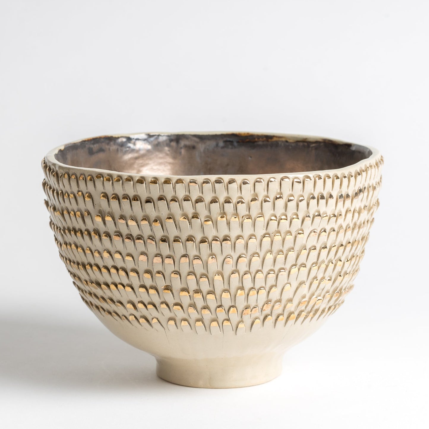 white and gold spiky vessel